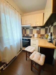 a kitchen with two stools in a small kitchen at Mara apartment in Băile Herculane