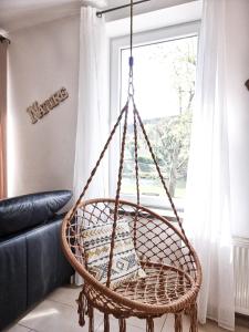 a rattan swing chair in a living room with a window at Holiday Home Leonie in Bollendorf