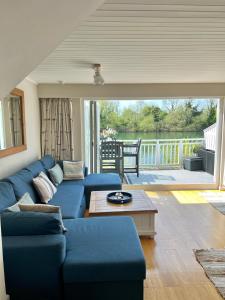 uma sala de estar com um sofá azul e uma mesa em Herons Hideout em South Cerney