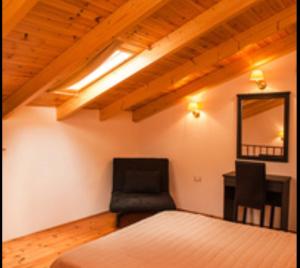 1 dormitorio con cama, silla y escritorio en Summer Garden Αpartments & Studios en Argostoli