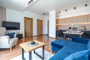 sala de estar con sofás azules y cocina en Apartamenty Aparts4U en Szklarska Poręba