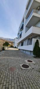 a large apartment building with a brick road in front of it at Sea View apartment in Vlorë