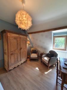 a living room with a large chandelier and chairs at LE CLOS JOLY 14 in Saint-Gâtien-des-Bois