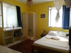 1 dormitorio con cama, ventana y ducha en Ecer Pansiyon, en Kusadasi