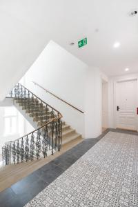 a white hallway with stairs and a rug at Sophienne Apartments in Vienna