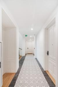 un pasillo vacío con paredes blancas y puertas blancas en Sophienne Apartments, en Viena