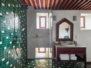 La salle de bains est pourvue d'un lavabo et d'un miroir. dans l'établissement Dar Roumana, à Fès