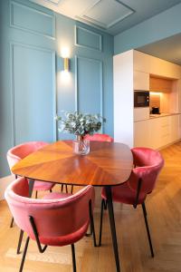comedor con mesa de madera y sillas rojas en HM - Infante Riverside Apartment K en Oporto
