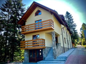 una casa con balcones de madera en un lateral en Agroturystyka Pod Jodłami en Żabnica