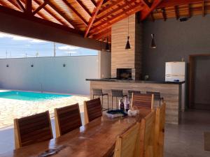 a dining room with a table and a swimming pool at Recanto Asa Delta in Olímpia