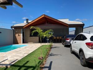 a house with a car parked in front of it at Recanto Asa Delta in Olímpia