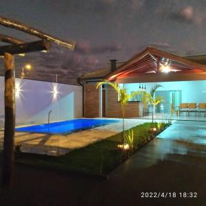 a house with a swimming pool at night at Recanto Asa Delta in Olímpia