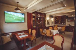 a restaurant with tables and chairs and a television on the wall at Provence rooms in Banja Luka