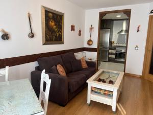 sala de estar con sofá y mesa en A. Rural LA COVATILLA en Navacarros, en Navacarros