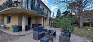 un patio avec des chaises et une table devant un bâtiment dans l'établissement Vakantiehuis & Gîte Rêve sous le Ciel, à Peyremale