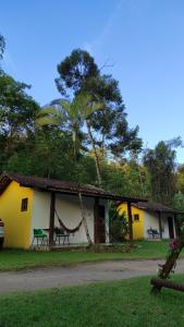 a house with a hammock in front of it at Recanto dos Pássaros - Sana Chalés in Sana