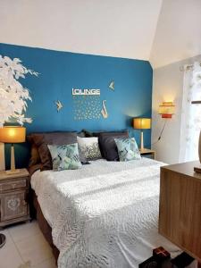 a bedroom with a bed with a blue wall at Coup de Coeur sur le Port de ST GOUSTAN, Trés Beau T2 avec Terrasse in Auray