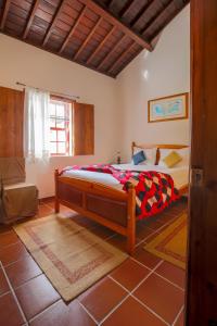 Biscoitos的住宿－Quinta dos Reis，卧室位于客房的角落,配有一张床