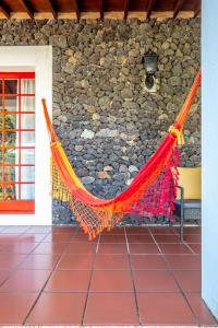 hamaca en una habitación con pared de piedra en Quinta dos Reis en Biscoitos