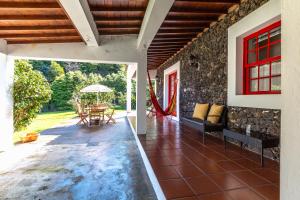 Zimmer mit einer Terrasse mit Tisch und Stühlen in der Unterkunft Quinta dos Reis in Biscoitos