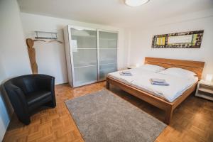 a bedroom with a bed and a black chair at Apartment pri Povhih in Slovenske Konjice