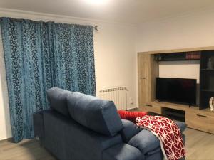 a living room with a couch and a television at casa Encarni, balcon de las cuevas in Setenil