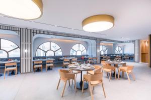 a dining room with tables and chairs and windows at Assaafa Hotel in Medina