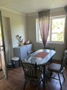 a dining room with a table and chairs and a window at Стаи за гости Дворъ in Varna City