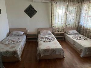 a room with two beds and a window at Стаи за гости Дворъ in Varna City