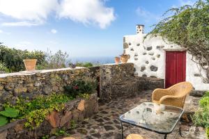 ein Haus mit einer roten Tür und einer Steinmauer in der Unterkunft CASA DE ITA in Erese