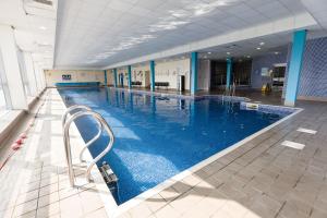 a large indoor swimming pool with blue water at Sporting Lodge Inn Middlesbrough in Middlesbrough