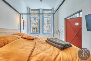 ein Schlafzimmer mit einem großen Bett mit einer orangefarbenen Bettdecke in der Unterkunft casanando prestige Suites - HiFi Erlebnis in Zoo - und Citylage in Leipzig