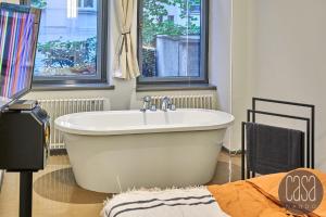 eine weiße Badewanne im Bad mit 2 Fenstern in der Unterkunft City Apartments Leipzig - Ruhig, zentral & nahe Zoo in Leipzig + 33 Fotos