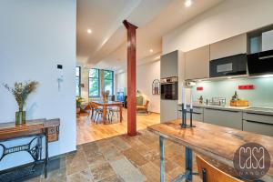 a kitchen and living room with a wooden table at casanando prestige Suites - HiFi Erlebnis in Zoo - und Citylage in Leipzig