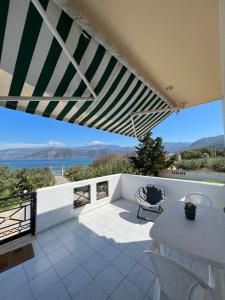 a balcony with a table and chairs and a view of the ocean at Alepochori Seaside Village in Kato Alepochori