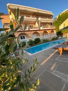 a hotel with a swimming pool in front of a building at Ionian Bay Rooms in Qeparo