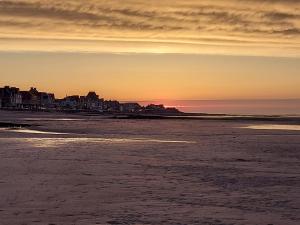 a view of the beach at sunset at Appartement avec Terrasse-Plein pied ou Chambre -Plein pied in Saint-Aubin-sur-Mer