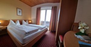 a hotel room with two beds and a window at Reiterhof Edelweiss in San Genesio Atesino