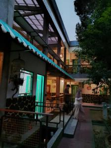 a woman walking down a sidewalk in front of a building at Joglo Aruna SYARIAH in Yogyakarta