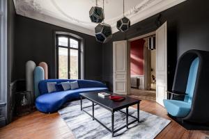 a living room with a blue couch and a table at Les Argentiers - Accès digitalisé in Limoges