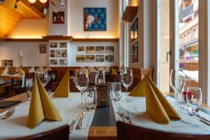 a restaurant with a table with yellow napkins on it at Hotel Victoria Lauberhorn Wengen, a Faern Collection Hotel in Wengen
