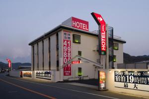 een hotel met borden aan de straatkant bij Hotel ニャンだふる in Himeji