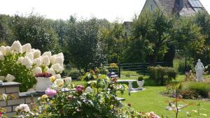 a garden with flowers and people sitting in the grass at Ferienwohnung und Gästezimmer Iburgblick in Bad Driburg