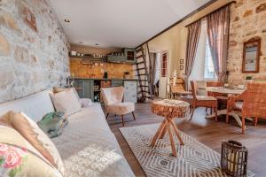 Mouragia Loft - Waterfront Old Corfu Town في مدينة كورفو: غرفة معيشة مع أريكة وطاولة