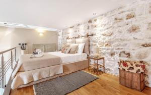 - une chambre avec un lit et un mur en pierre dans l'établissement Mouragia Loft - Waterfront Old Corfu Town, à Corfou