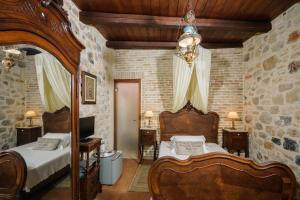 a bedroom with two beds and a stone wall at Casa Di Veneto in Hersonissos