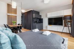 a living room with a bed and a dining room at Audrey DeLux Seaview Gardenia Studio in Dziwnów