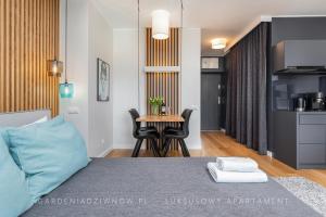 a bedroom with a bed and a table with chairs at Audrey DeLux Seaview Gardenia Studio in Dziwnów