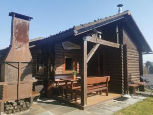 a log cabin with a table and a bench at Cottage Barbara with Sauna in Škofja Loka