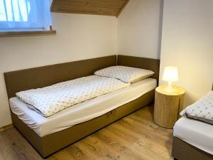 Dormitorio pequeño con 2 camas y lámpara en Agroturystyka Pod Jodłami en Żabnica